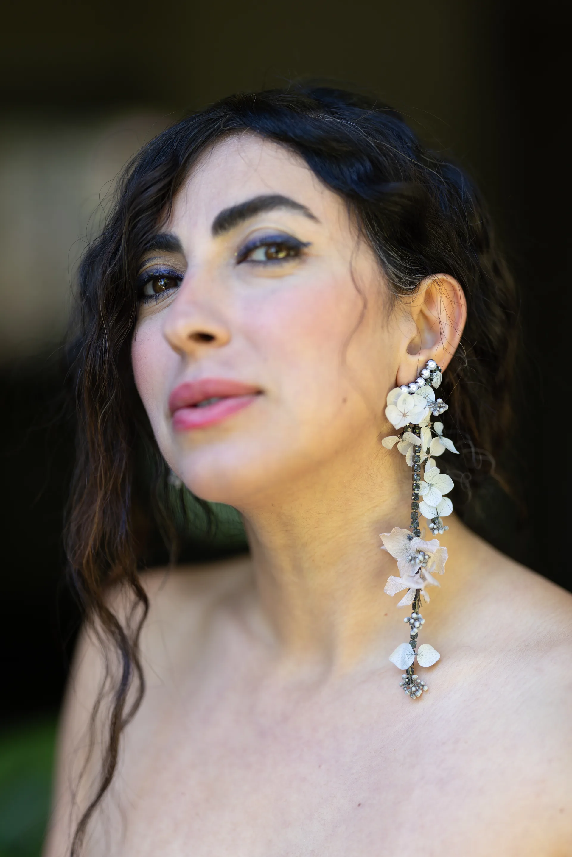 Profile view of a long dried hydrangea and pearl drop earring